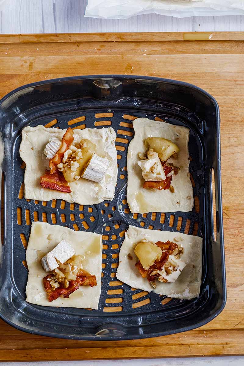 Air Fryer Peach Maple Bacon Brie Bites uncooked in the air fryer basket