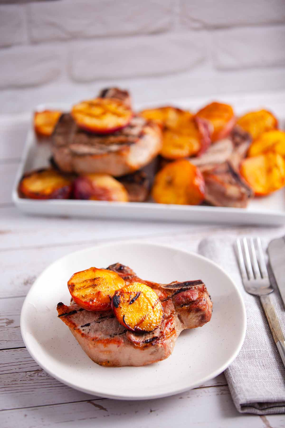plate grilled pork chops and peaches